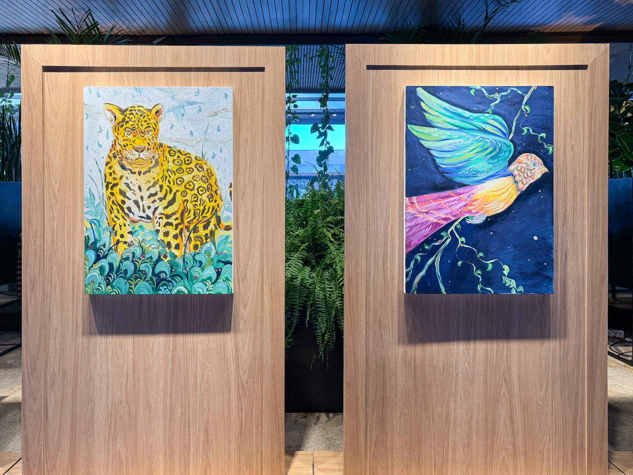 Painéis com a onça-pintada e a ave de cauda colorida, vistos de frente